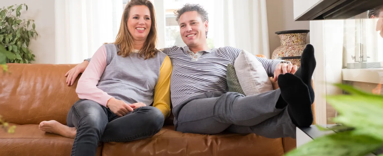 Twee personen zitten samen op de bank.