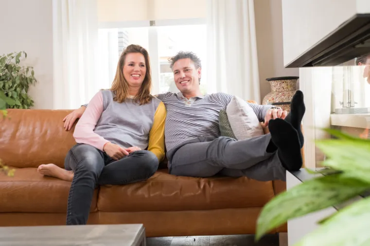 Twee personen zitten samen op de bank.